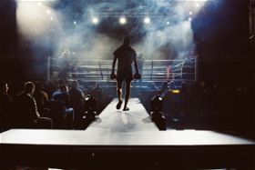 Man Walking Into Boxing Ring for Chatbots vs Live Chat Showdown - What Reigns Supreme?